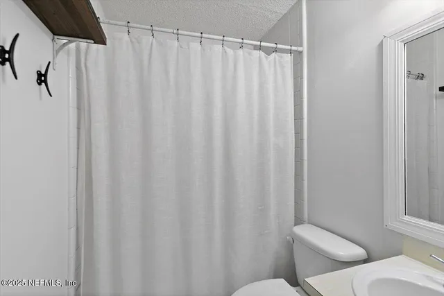 a bathroom with a toilet and a shower curtain