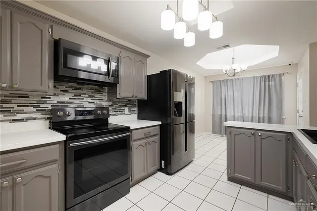 a kitchen with granite countertop a stove sink and refrigerator