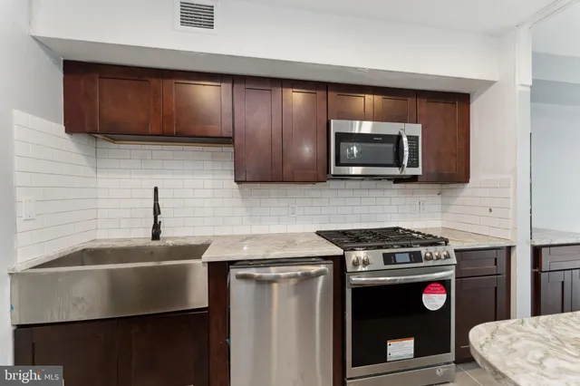 a kitchen with stainless steel appliances a stove a microwave sink and cabinets