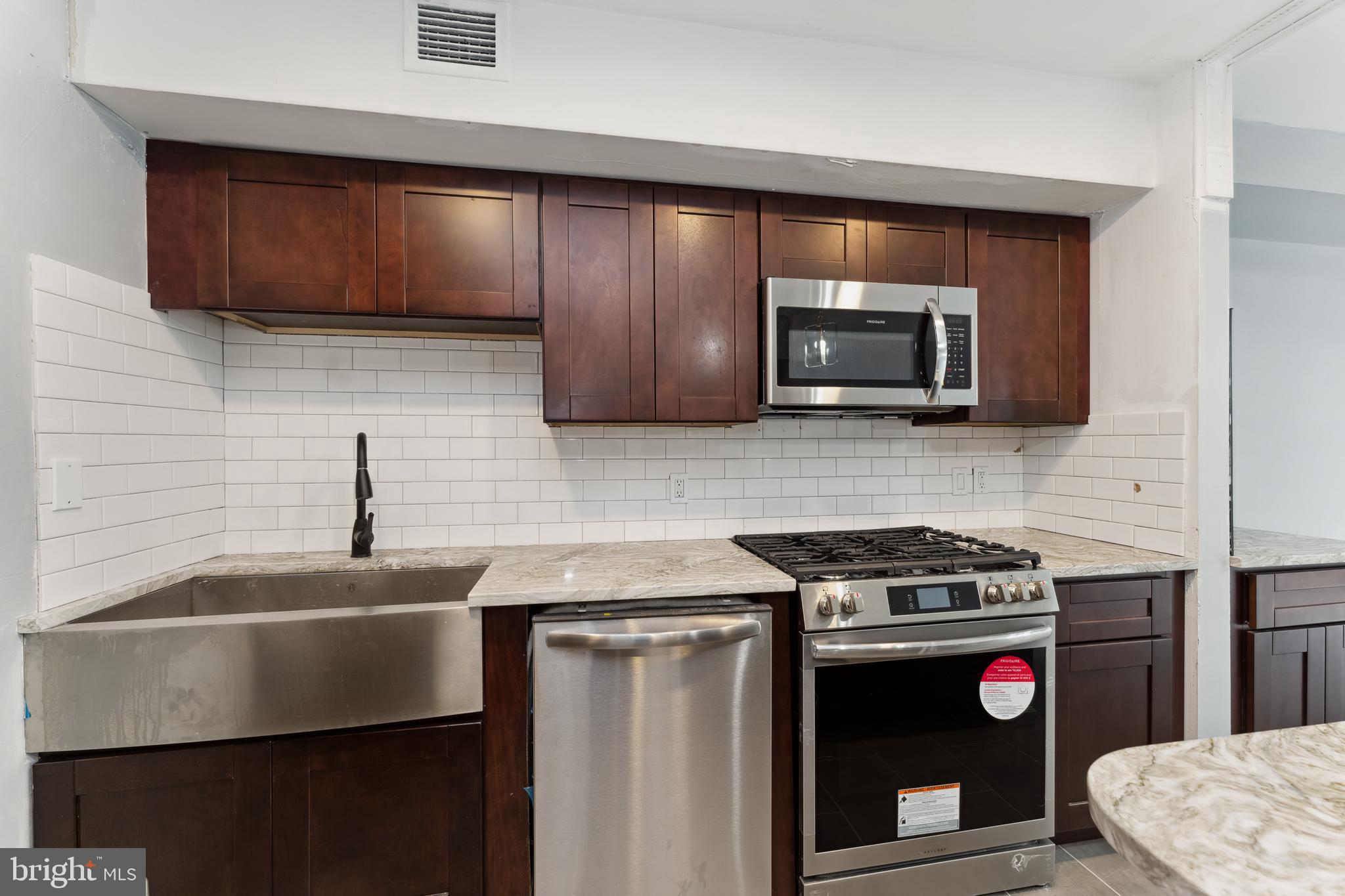 212 G Street Southwest, Unit 212 Washington, DC 20024 - Photo 5 of 17 a kitchen with stainless steel appliances a stove a microwave sink and cabinets