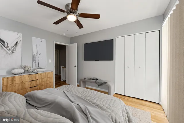 a bedroom with a bed and a flat tv screen on dresser