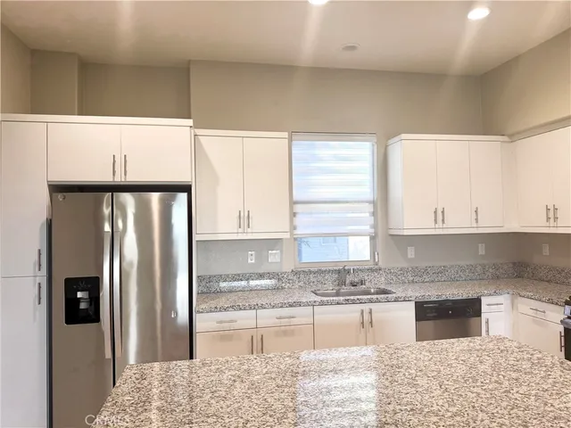 a kitchen with granite countertop a stove a sink and a microwave