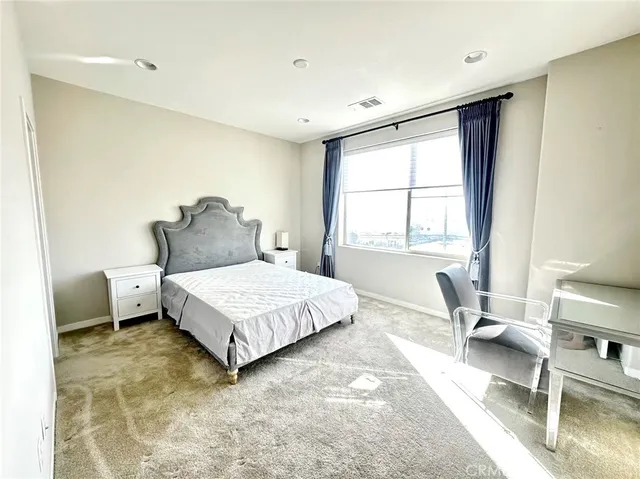 a bedroom with a bed and a large window