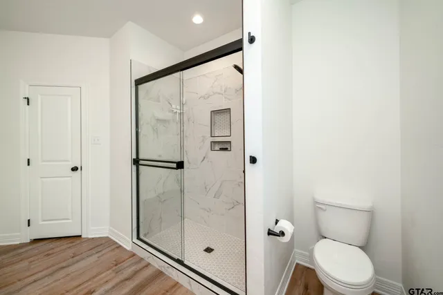 a bathroom with a toilet and a shower