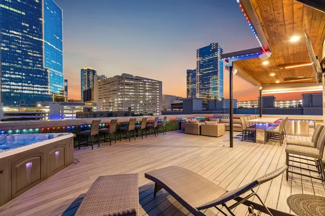 a view of a rooftop deck with chairs and city view