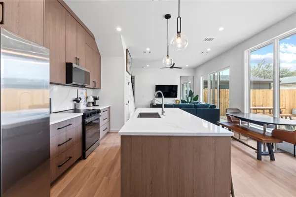 a large kitchen with stainless steel appliances kitchen island granite countertop a sink a stove and a refrigerator