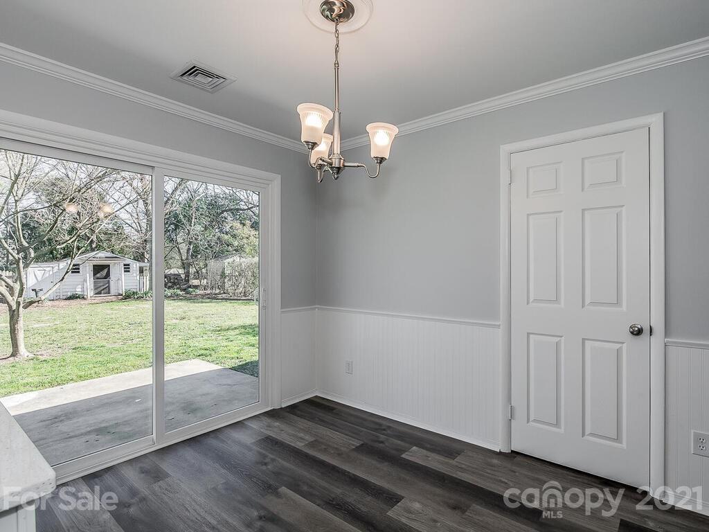 5223 Seacroft Road Charlotte, NC 28210 - Photo 11 of 23 a view of a livingroom with wooden floor a ceiling fan and windows
