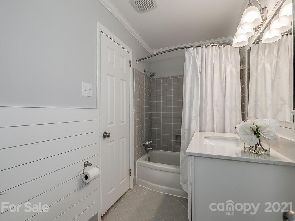 5223 Seacroft Road Charlotte, NC 28210 - Photo 15 of 23 a bathroom with a tub a sink and a large mirror