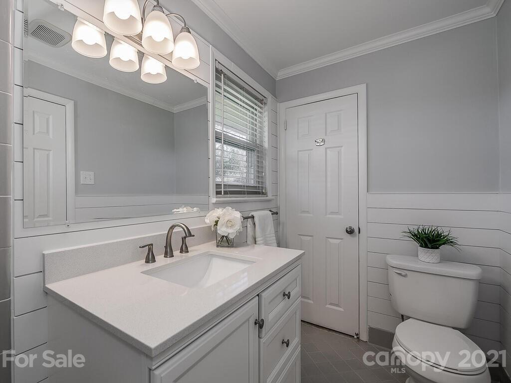 5223 Seacroft Road Charlotte, NC 28210 - Photo 16 of 23 a bathroom with a sink toilet a mirror and vanity