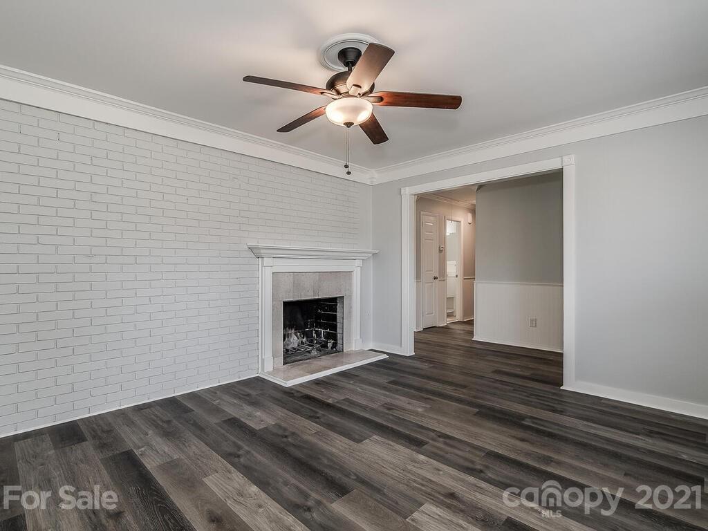 5223 Seacroft Road Charlotte, NC 28210 - Photo 4 of 23 a view of an empty room with wooden floor fireplace and a window