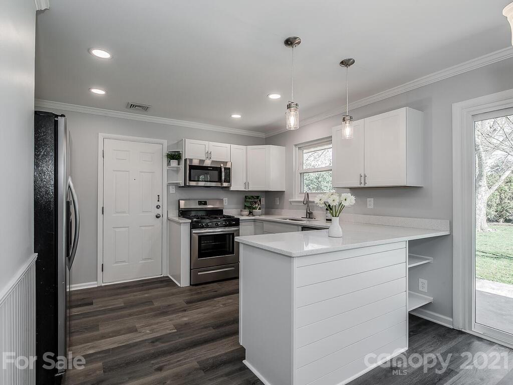 5223 Seacroft Road Charlotte, NC 28210 - Photo 6 of 23 a kitchen with stainless steel appliances kitchen island granite countertop a refrigerator and a stove top oven