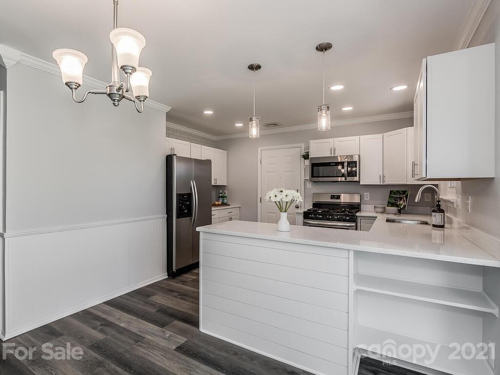 5223 Seacroft Road Charlotte, NC 28210 - Photo 7 of 23 a kitchen with kitchen island white cabinets and stainless steel appliances