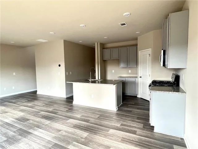 a view of a kitchen with wooden floor and a window