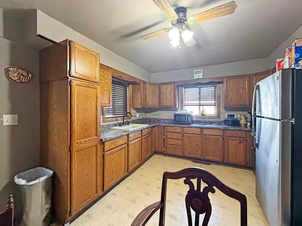 a kitchen with stainless steel appliances granite countertop a refrigerator a sink a stove and island