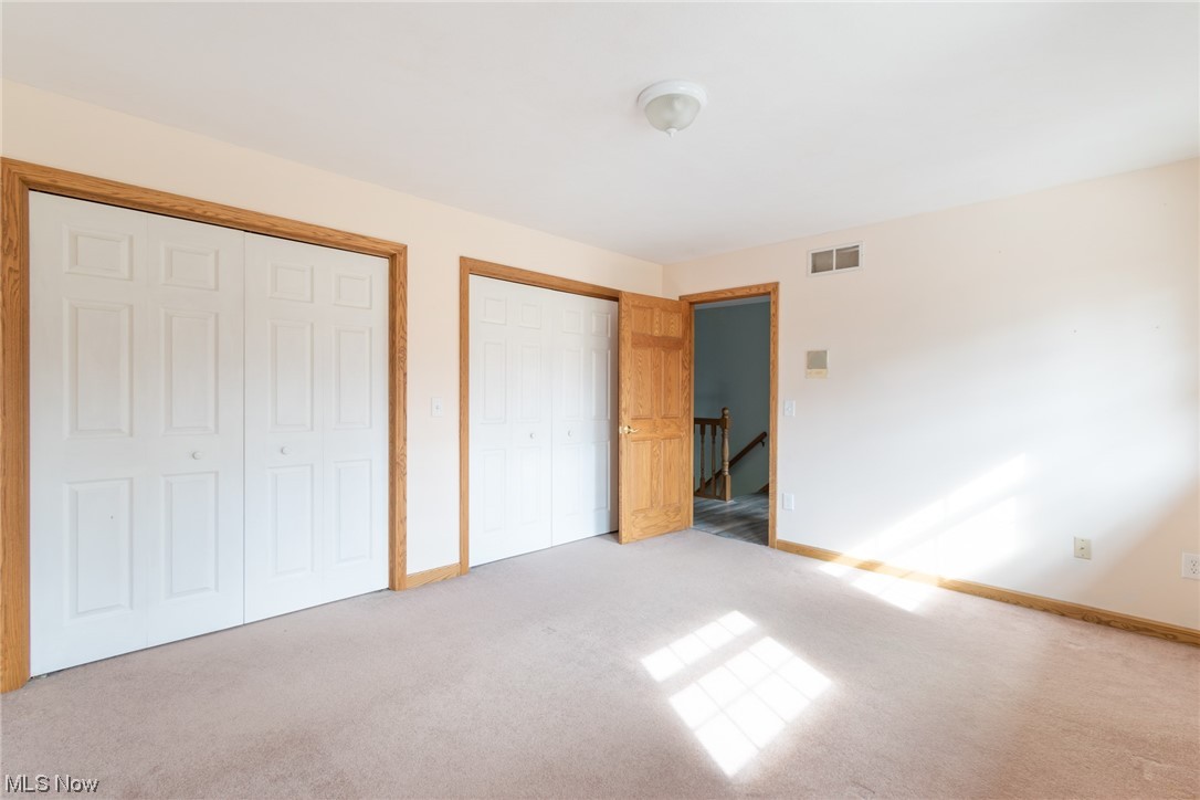 8089 Thomas Road Lisbon, OH 44432 - Photo 30 of 46 Unfurnished bedroom with light colored carpet and two closets
