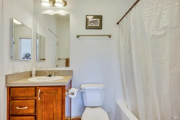 a bathroom with a sink a toilet and shower curtain