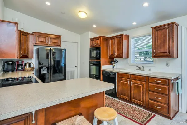 a kitchen with stainless steel appliances a sink cabinets and wooden floor