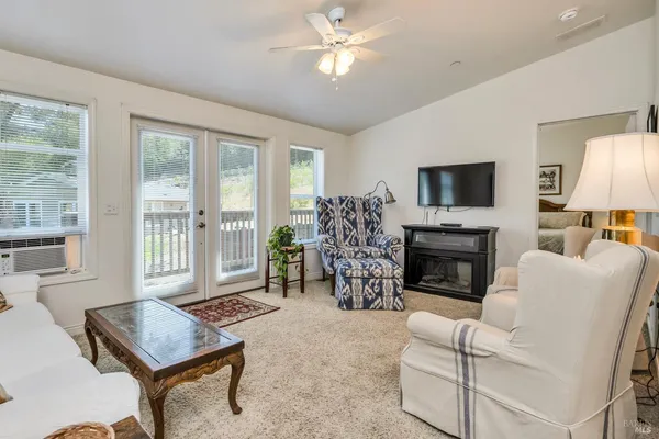 a living room with furniture a fireplace and a flat screen tv