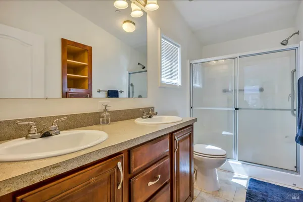 a bathroom with a granite countertop sink toilet and mirror