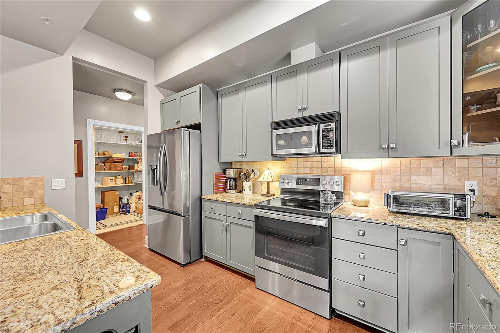 1352 Pennsylvania Street, Unit 2 Denver, CO 80203 - Photo 19 of 45 a kitchen with stainless steel appliances granite countertop a refrigerator stove and sink