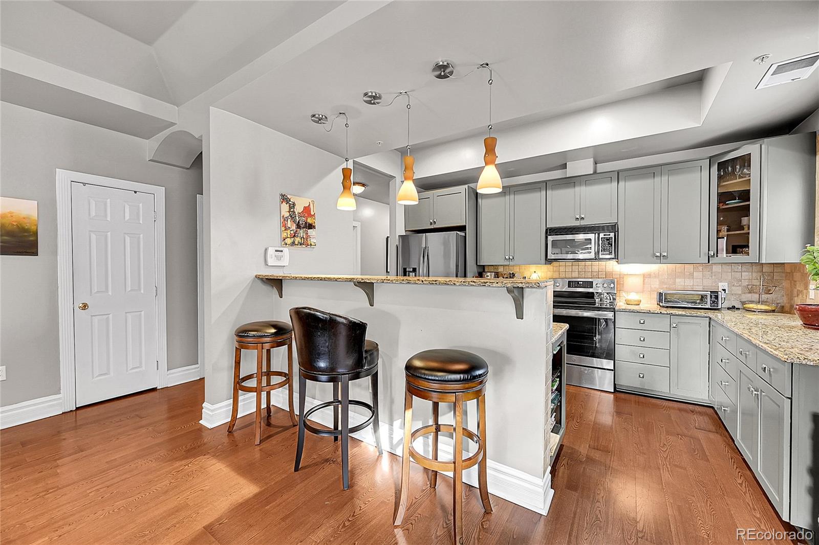 1352 Pennsylvania Street, Unit 2 Denver, CO 80203 - Photo 20 of 45 a kitchen with a table chairs refrigerator and microwave
