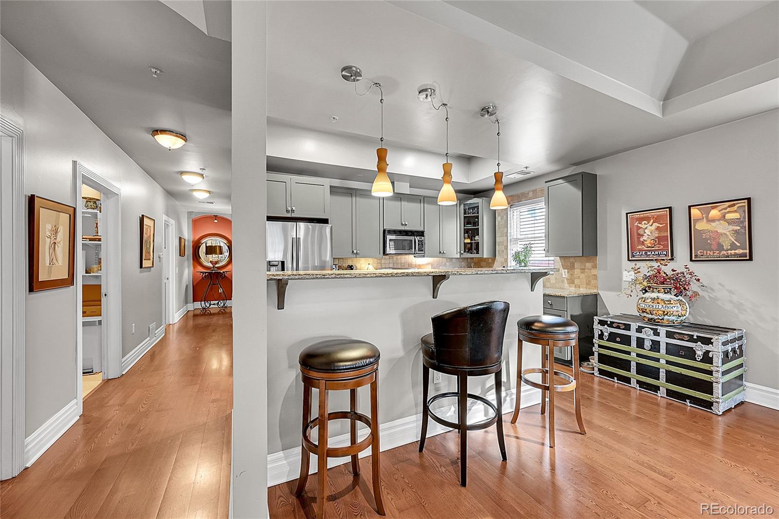 1352 Pennsylvania Street, Unit 2 Denver, CO 80203 - Photo 21 of 45 a open kitchen with stainless steel appliances granite countertop a refrigerator a stove a dining table and chairs with wooden floor