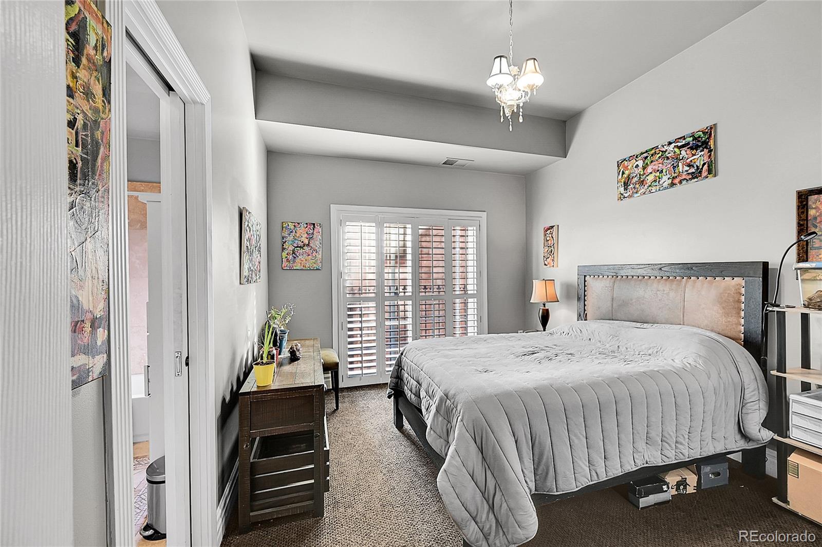 1352 Pennsylvania Street, Unit 2 Denver, CO 80203 - Photo 25 of 45 a bedroom with a bed and a chandelier