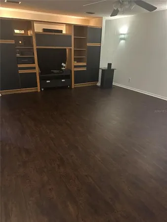a view of an empty room with stairs and furniture