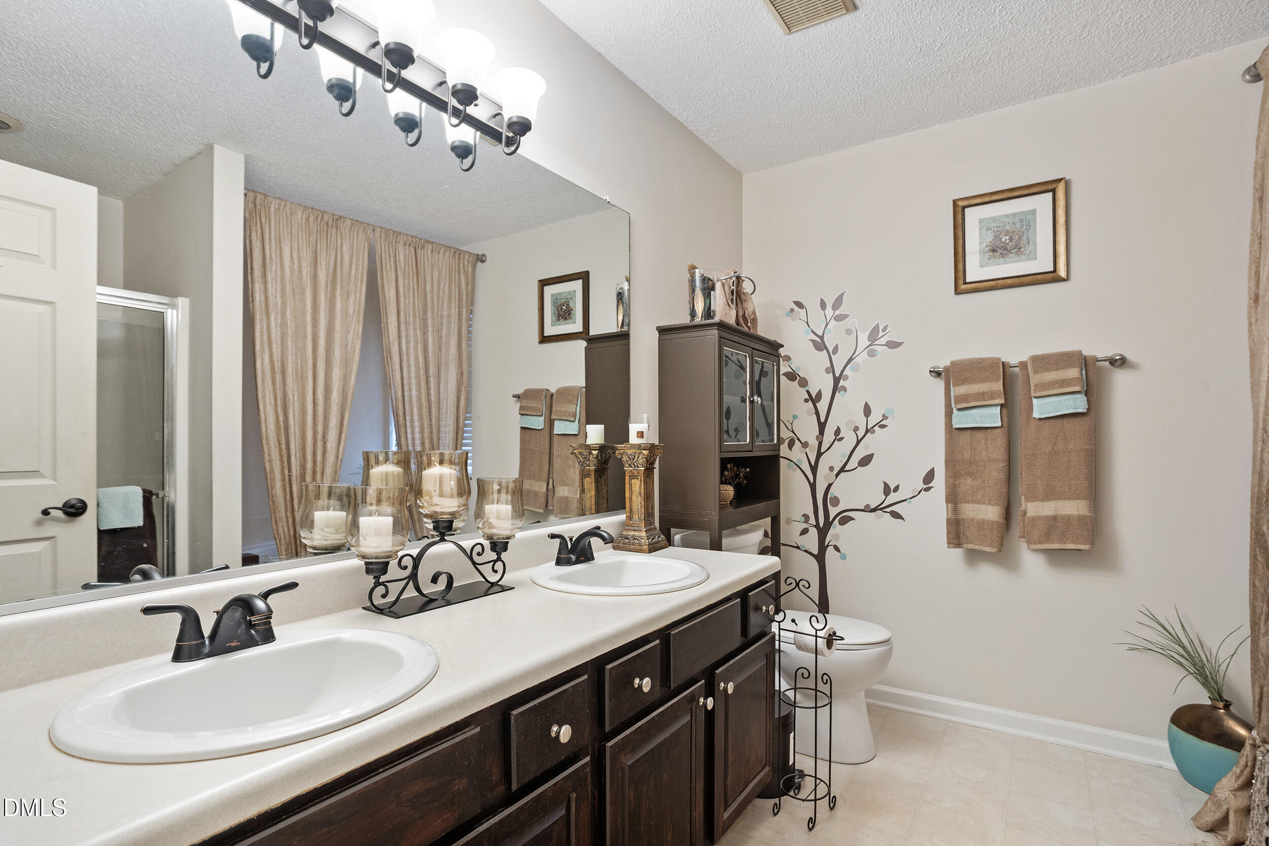 101 Cedar Key Landing Garner, NC 27529 - Photo 20 of 37 a bathroom with double vanity sinks a toilet a mirror and shower