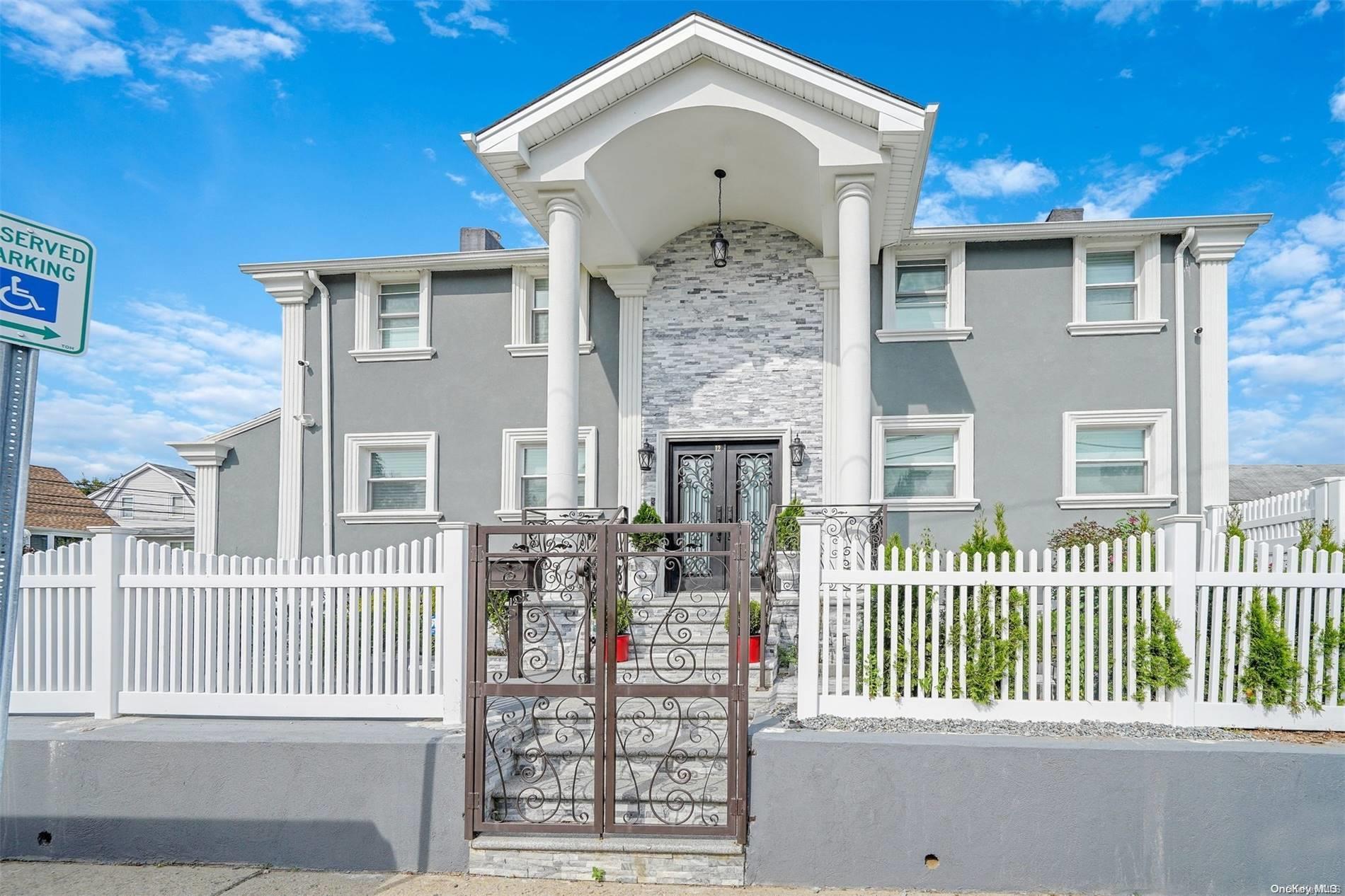 a front view of a house with iron fence