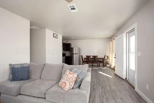 a living room with furniture and kitchen view