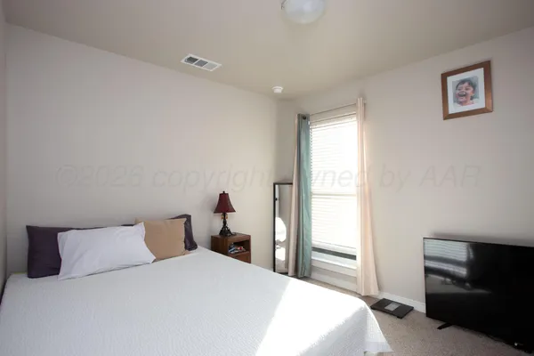 a bedroom with a bed and a tv