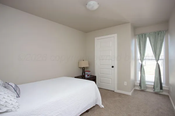 a bedroom with a bed and a large window