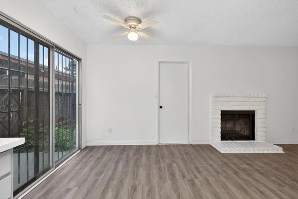 an empty room with wooden floor a fireplace
