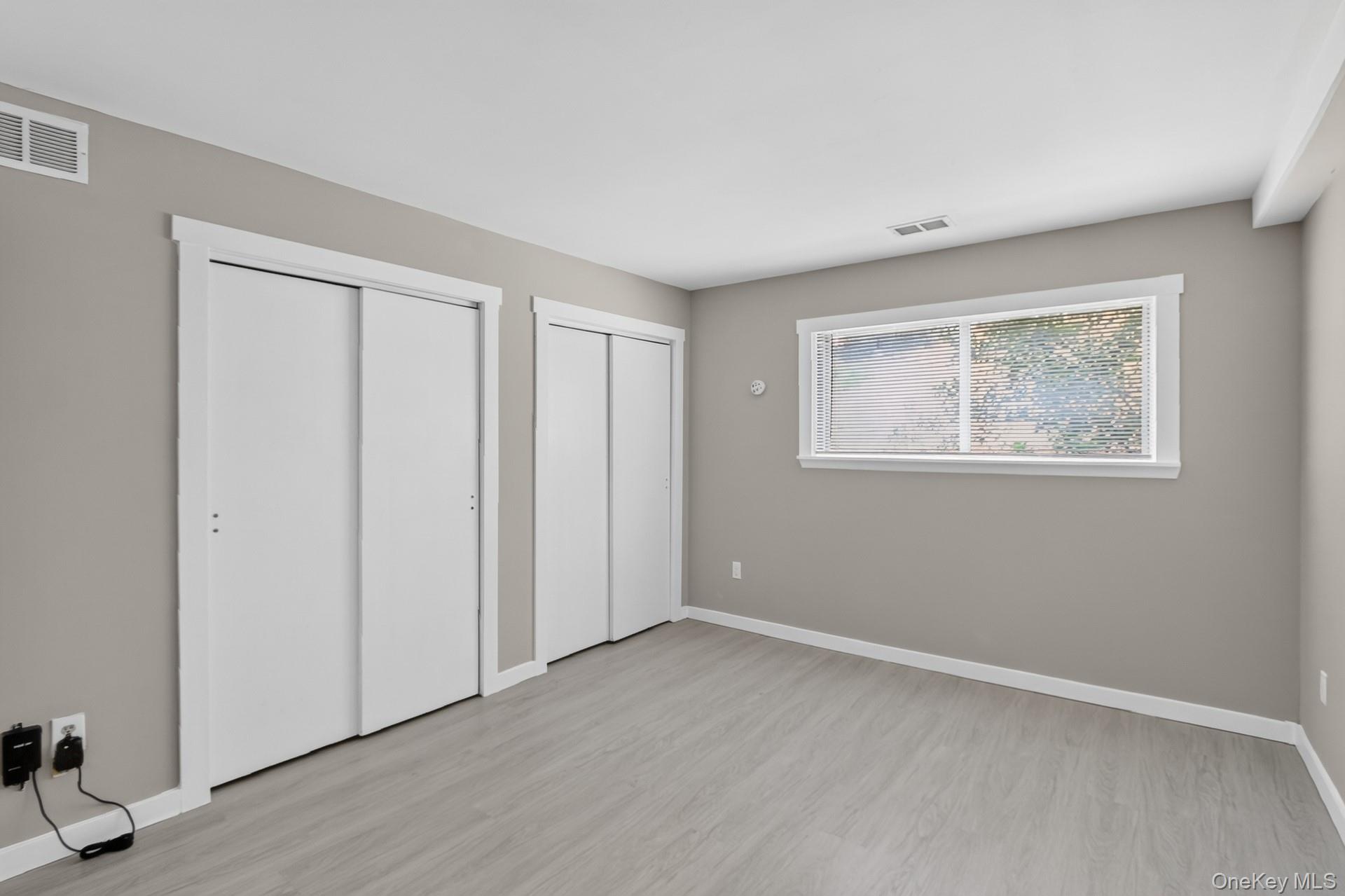 26 Cooper Road, Unit 414 Poughkeepsie, NY 12603 - Photo 10 of 24 Spacious room featuring light gray walls and wood-finish flooring