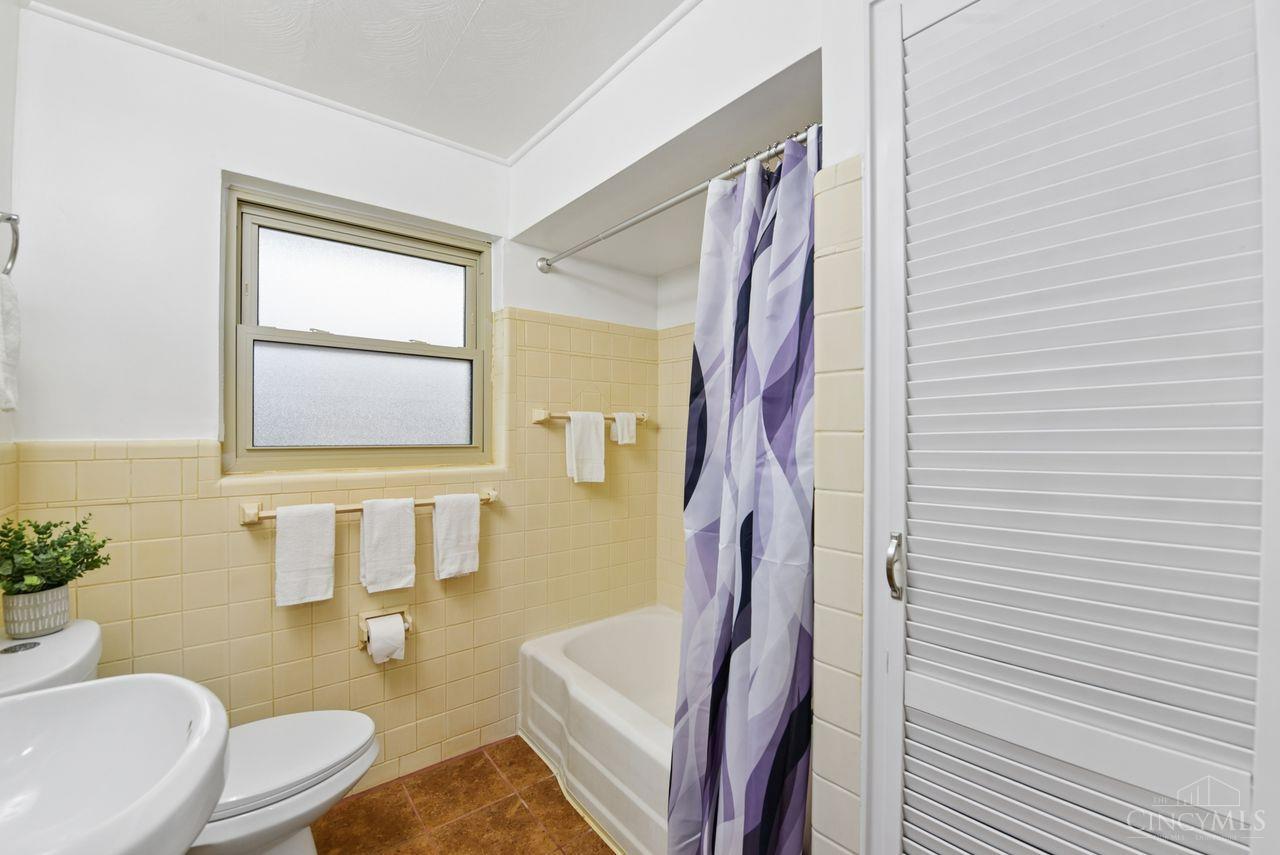 5258 Shepherd Road Cincinnati, OH 45223 - Photo 27 of 43 The Full Bath features a Tub/Shower combination with ceramic tiled walls, a tiled floor, an updated Pedestal Sink, a Dual Flush Toilet, and Wide Mirrored Medicine Cabinet. This view also shows the door to the Linen Closet in this attractive Bathroom!