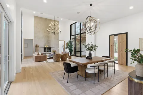 a kitchen with stainless steel appliances granite countertop a table and a chandelier