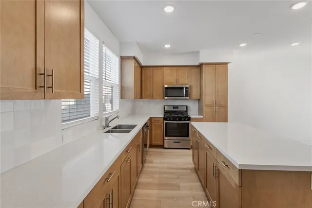 a kitchen with stainless steel appliances granite countertop a sink and a stove top oven