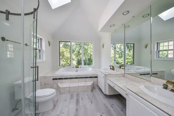 a bathroom with a granite countertop sink toilet a large mirror and shower