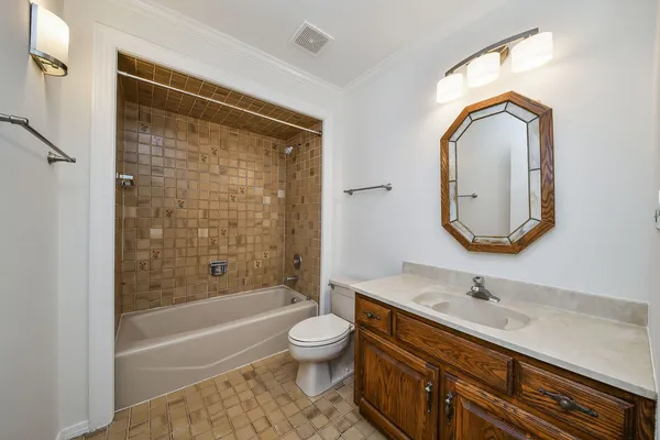 a bathroom with a granite countertop sink toilet a mirror and bathtub