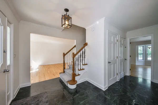 a view of empty room with stairs and wooden floor