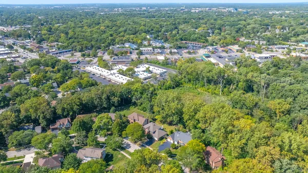 an aerial view of residential house with outdoor space and trees all around