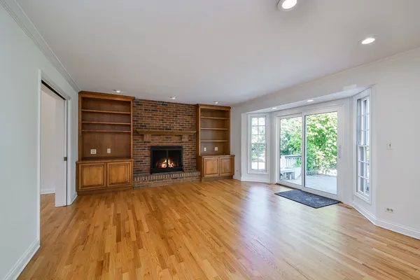 a view of an empty room with a fireplace and a window