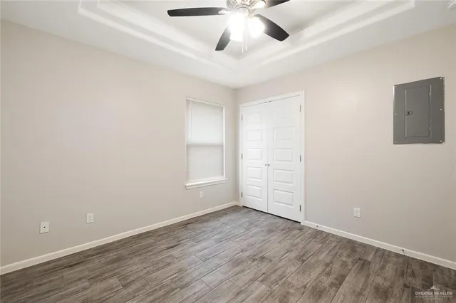 an empty room with fan and windows
