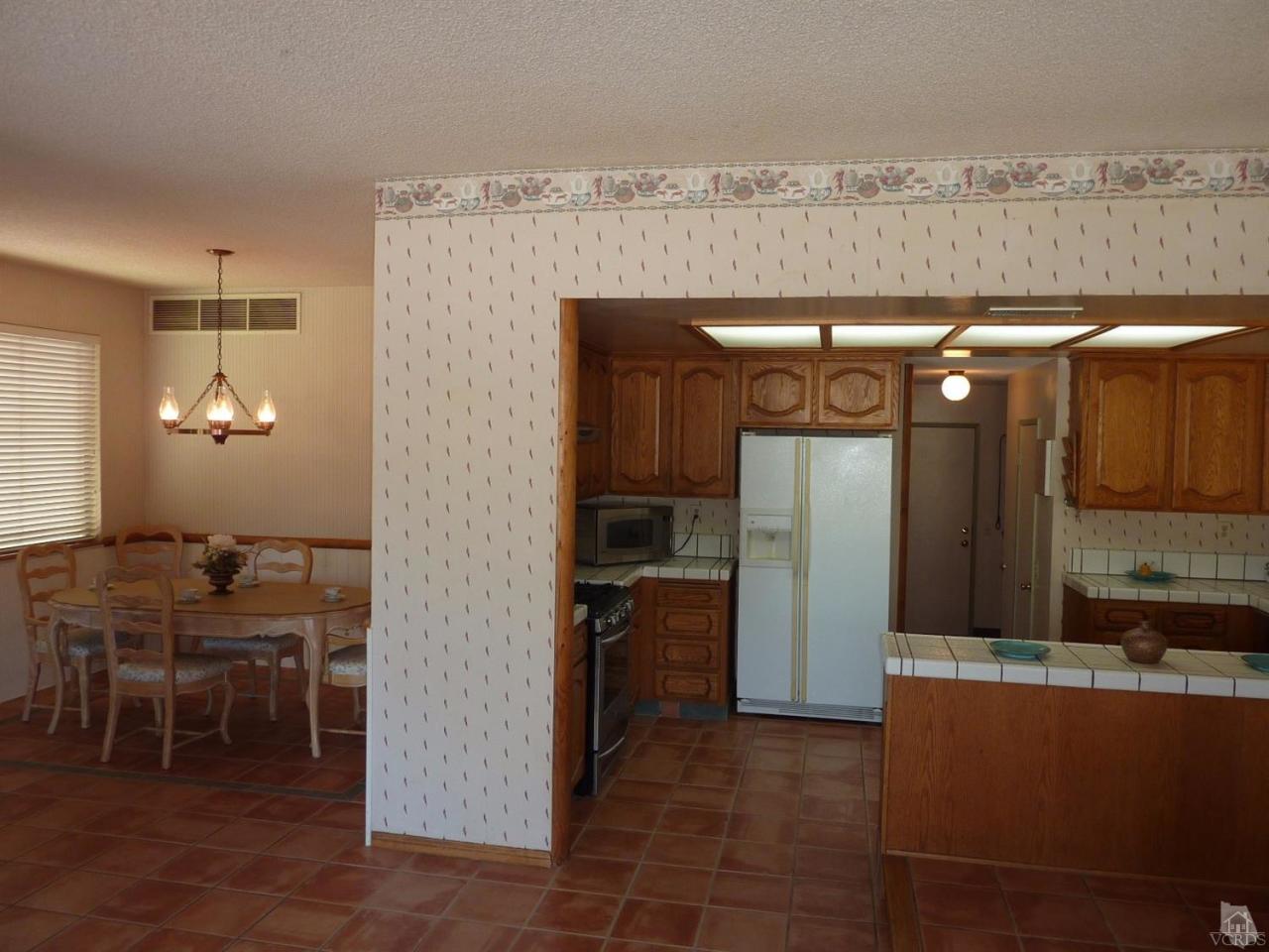 1707 Rambling Road Simi Valley, CA 93065 - Photo 14 of 29 a kitchen with stainless steel appliances kitchen island granite countertop dining table and chairs