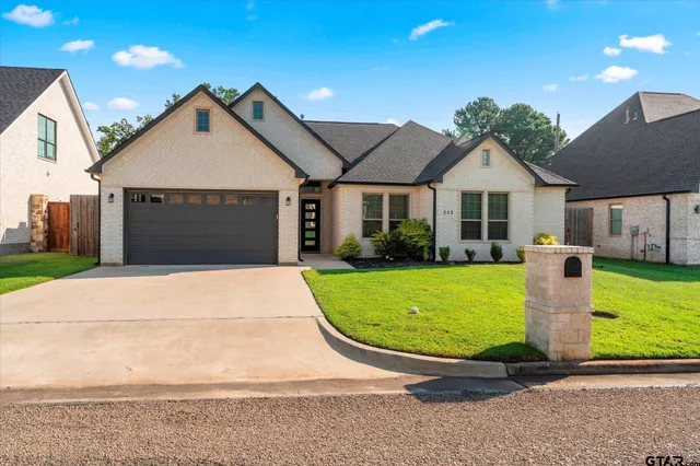 a front view of a house with a yard and garage