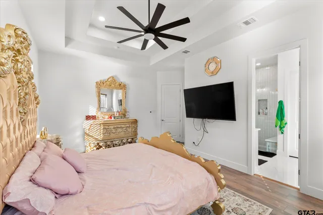 a bedroom with a bed a window and a flat screen tv