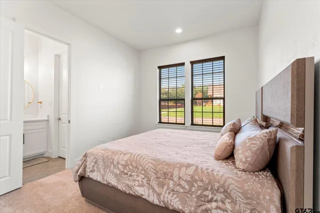 a bedroom with a large bed and a flat tv screen