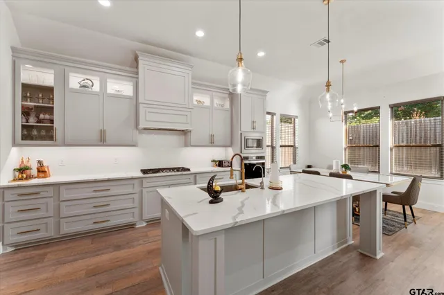 a kitchen that has a lot of cabinets in it and stainless steel appliances