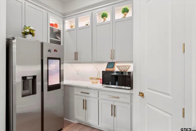 a kitchen with stainless steel appliances white cabinets and a refrigerator